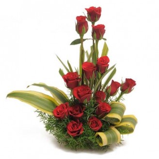 BEAUTIFUL ARRANGEMENT OF ROSES IN A BASKET; 15 red roses along with green filler arranged in a basket. This basket can be kept as center piece for the decoration of a room. It can definetly add happiness and beauty to the room.